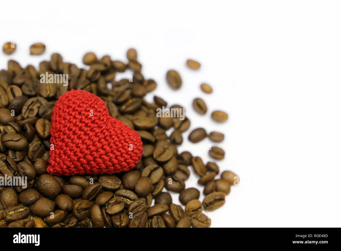 Liebe Kaffee, Valentine Herz und gerösteten Kaffeebohnen auf weißem Hintergrund. Rot gestrickt, Symbol der Liebe, Konzept der romantisches Frühstück Stockfoto
