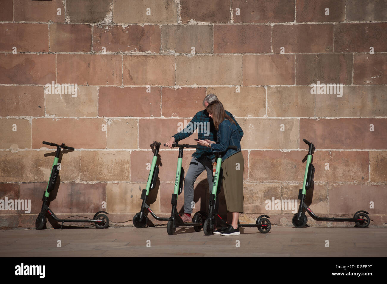 Touristen sind mit freien Elektroroller, wie sie auf der Straße geparkt werden gesehen. Der spanische General Traffic Management wird von nun an einen Führerschein für die elektroroller und eine Versicherung unter anderem Maßnahmen bedarf, entsprechend einer neuen Dekret von der spanischen Regierung. In den letzten Monaten hat mehr Unfälle mit Elektroroller passiert, und ein Tod im vergangenen Jahr. Die Regierung erwarten, wie dies der Verwendung dieser Transporte zu regulieren und die Sicherheit verbessern. Stockfoto