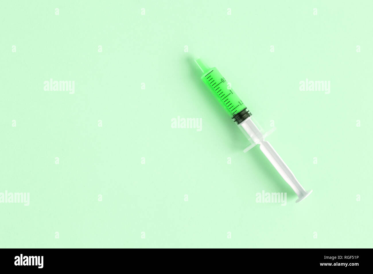 Flach der Spritze auf grünem Hintergrund minimal kreatives Konzept isoliert. Platz für Kopieren. Stockfoto