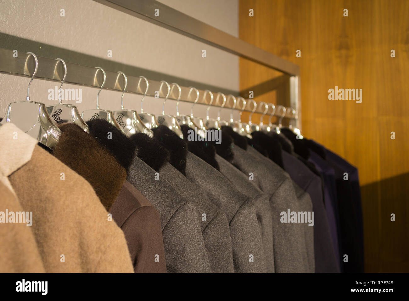 Verschiedene Farbe Männer Mäntel auf Kleiderbügel im Shop zum Verkauf Stockfoto