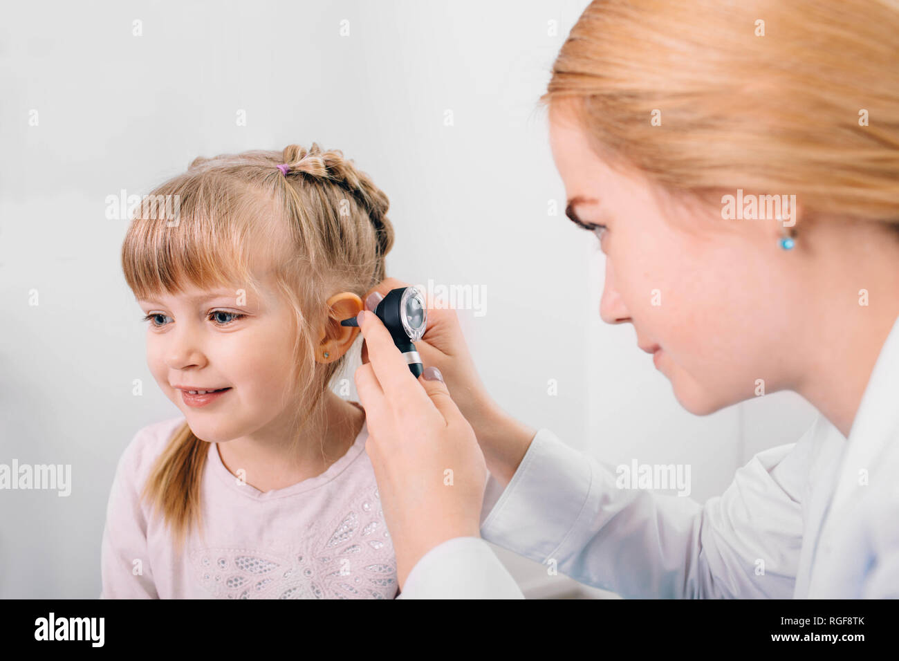 Lächelnde Mädchen in Ohr Untersuchung mit otoskop Stockfoto