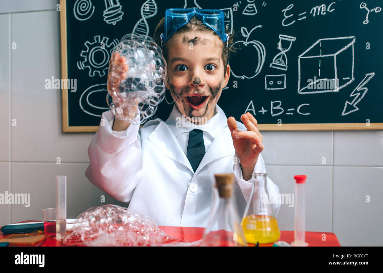 Lustige Happy Boy gekleidet als Chemiker mit schmutzigem Gesicht, nachdem Sie ein Experiment Stockfoto