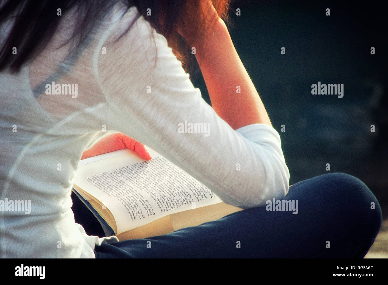 Ein Mädchen mit einem Buch in der Open Air und sitzt. Stockfoto