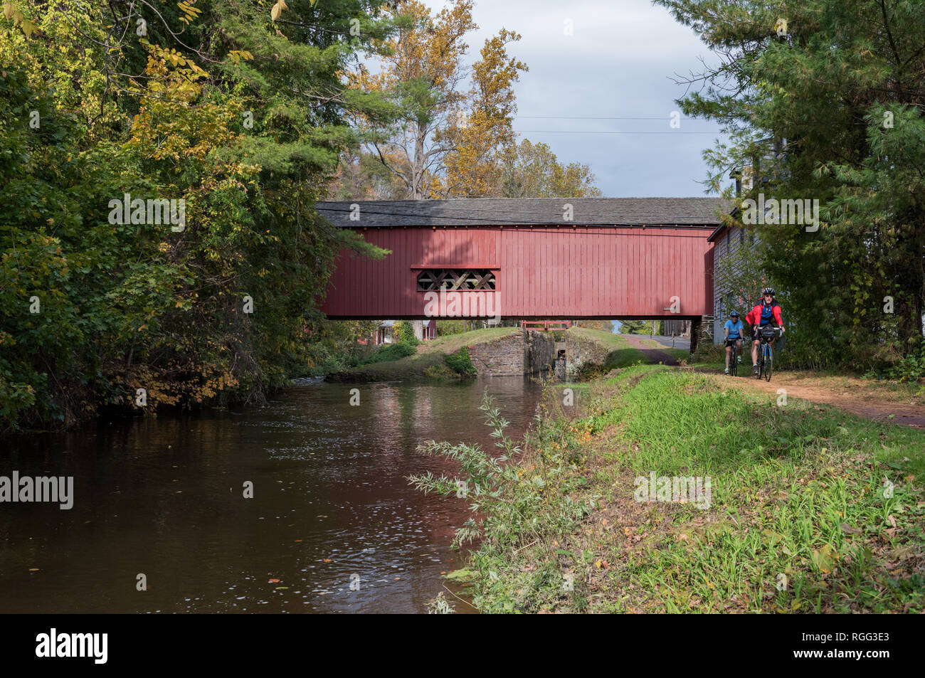 Radfahrer reiten unter Uhlerstown Covered Bridge, Bucks County PA Stockfoto