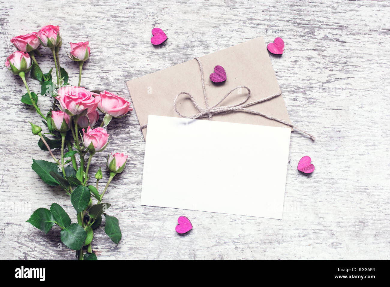 Stilvolle branding Mockup ihre Kunstwerke anzuzeigen. vintage Hochzeit Grußkarte mit Rosen und Herzen aus Holz mock up auf hölzernen Hintergrund. Valent Stockfoto