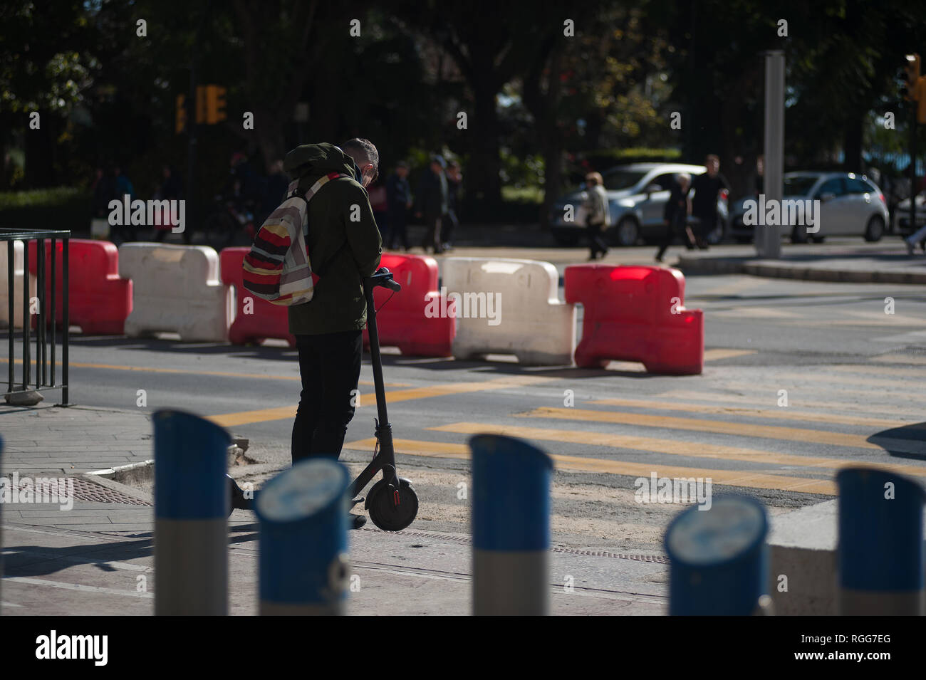 Ein Mann mit einem freien Elektroroller wird gesehen, seinem Mobiltelefon als Er wartet der Fußgängerampel überqueren. Der spanische General Traffic Management wird von nun an einen Führerschein für die elektroroller und eine Versicherung unter anderem Maßnahmen bedarf, entsprechend einer neuen Dekret von der spanischen Regierung. In den letzten Monaten hat mehr Unfälle mit Elektroroller passiert, und ein Tod im vergangenen Jahr. Die Regierung erwarten, wie dies der Verwendung dieser Transporte zu regulieren und die Sicherheit verbessern. Stockfoto