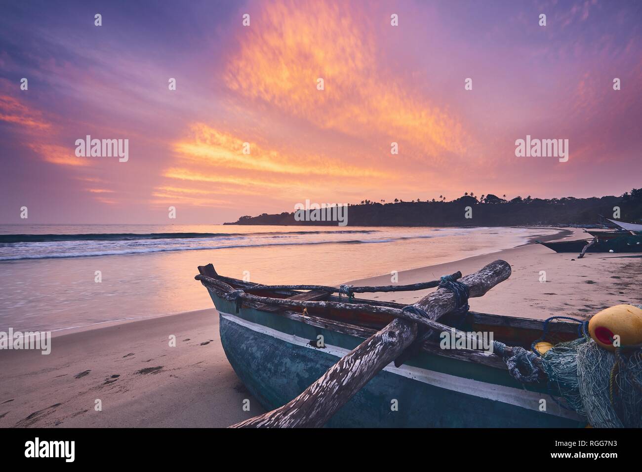 Fischerboot auf dem Sand strand gegen Bunte sunrise in der Nähe von Tangalle in Sri Lanka. Stockfoto