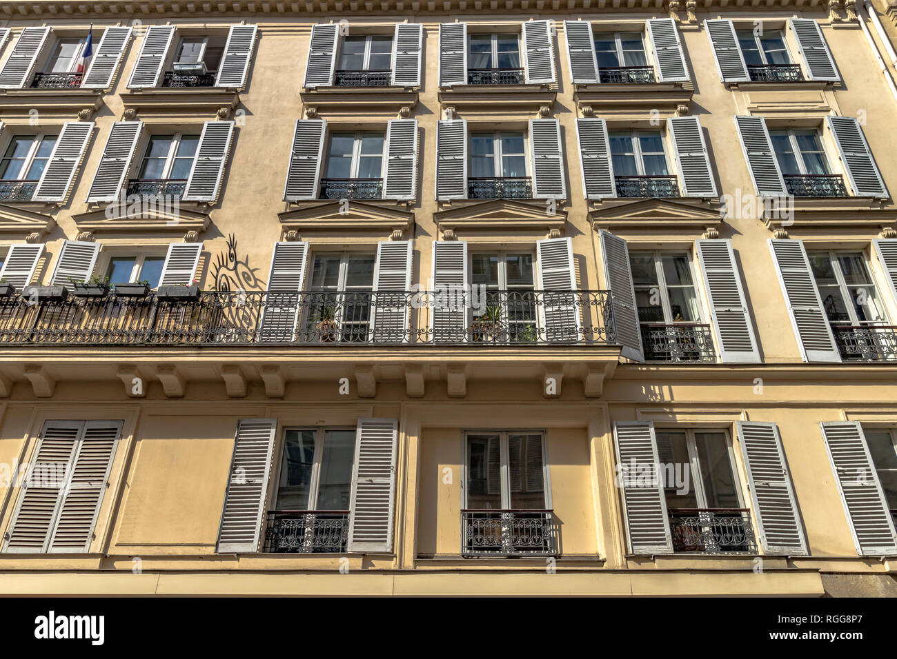 Weißen Fensterläden und schmiedeeisernen Balkon auf einer Wohnung Gebäude entlang der Rue Saint-Dominique, Paris, Frankreich Stockfoto