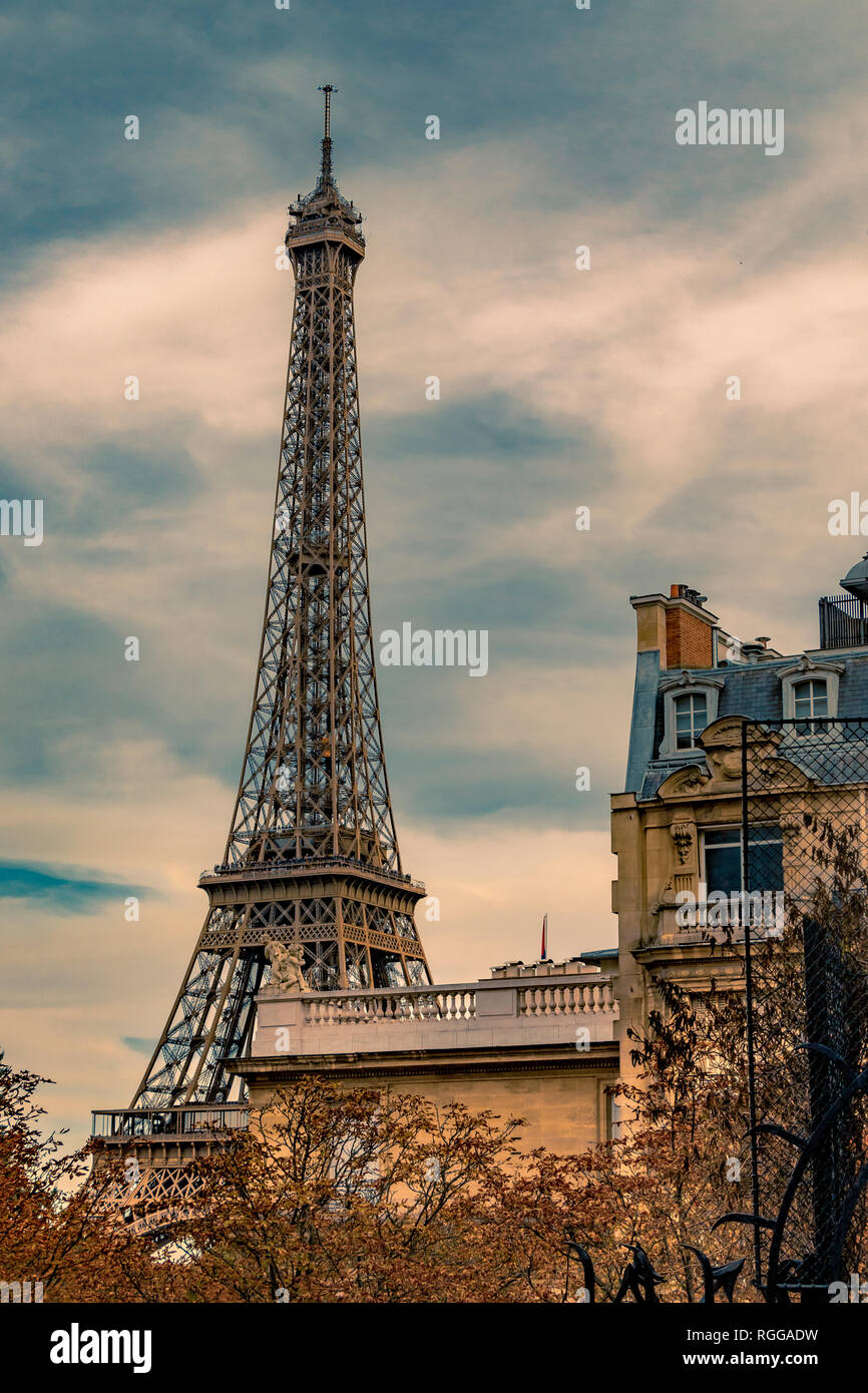 Der Eiffelturm sitzt hinter einem Grand Paris Wohnung Gebäude wie von der Avenue de Camoens mit den Bäumen drehen Ein herbstliches orange Farbe gesehen, Paris Stockfoto