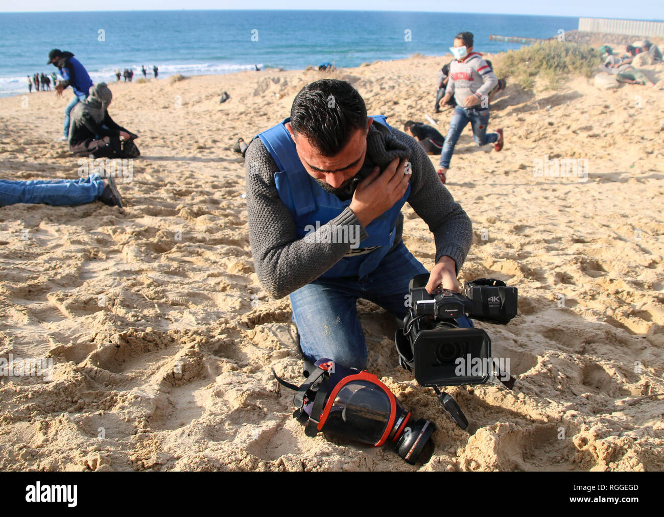 Palästinensische Journalist gesehen auf dem Boden liegend beim Einatmen Tränengas bei Zusammenstößen zwischen Palästinensern und israelischen Streitkräfte während Protestieren im nördlichen Gazastreifen. Stockfoto