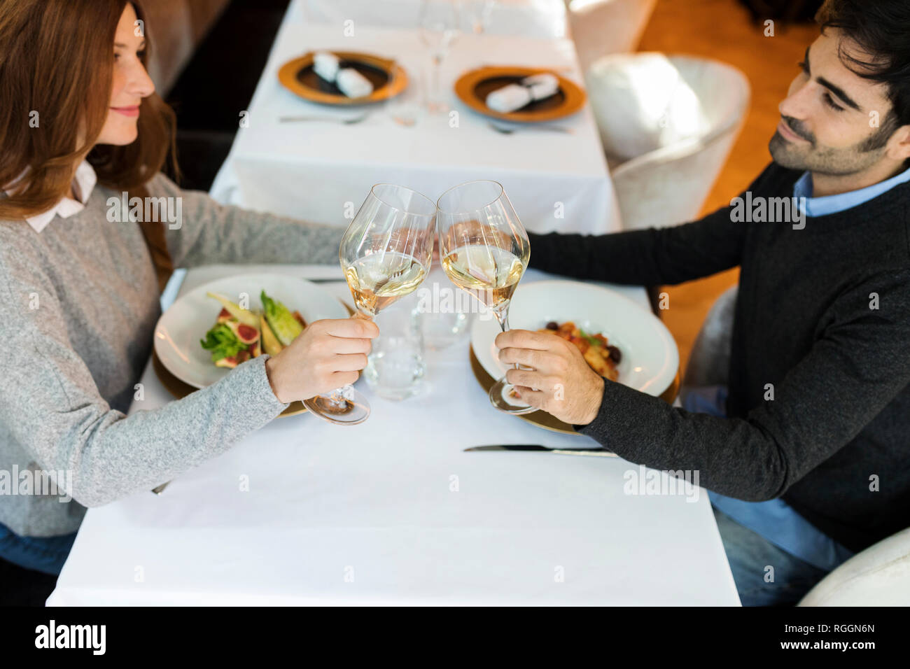 Lächelndes Paar klirren Gläser in einem Restaurant Stockfoto