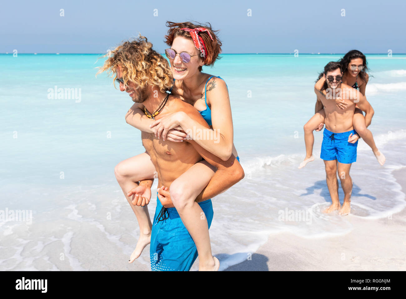 Freunde zu Fuß am Strand, mit Freundinnen piggyback Stockfoto