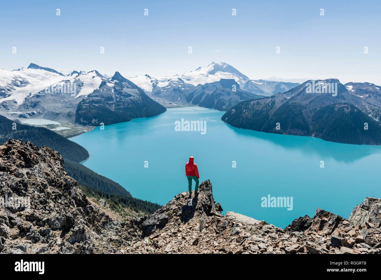 Blick vom Panorama Ridge Wanderweg, Wanderer auf einem Felsen, Garibaldi Lake, Guard Berg und Täuschung Gipfel, Gletscher zurück Stockfoto