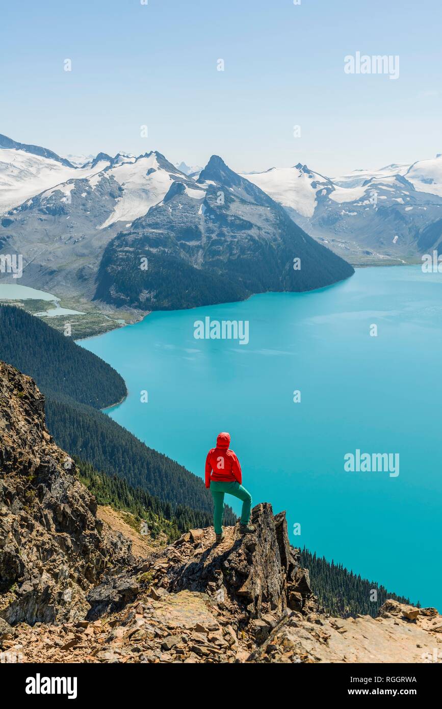 Blick vom Panorama Ridge Wanderweg, Wanderer auf einem Felsen, Garibaldi Lake, Guard Berg und Täuschung Gipfel, Gletscher zurück Stockfoto