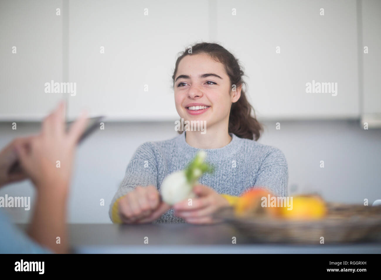 Portrait von lächelnden jungen Frau Zubereitung Fenchel in der Küche, während ihre Mutter Stockfoto