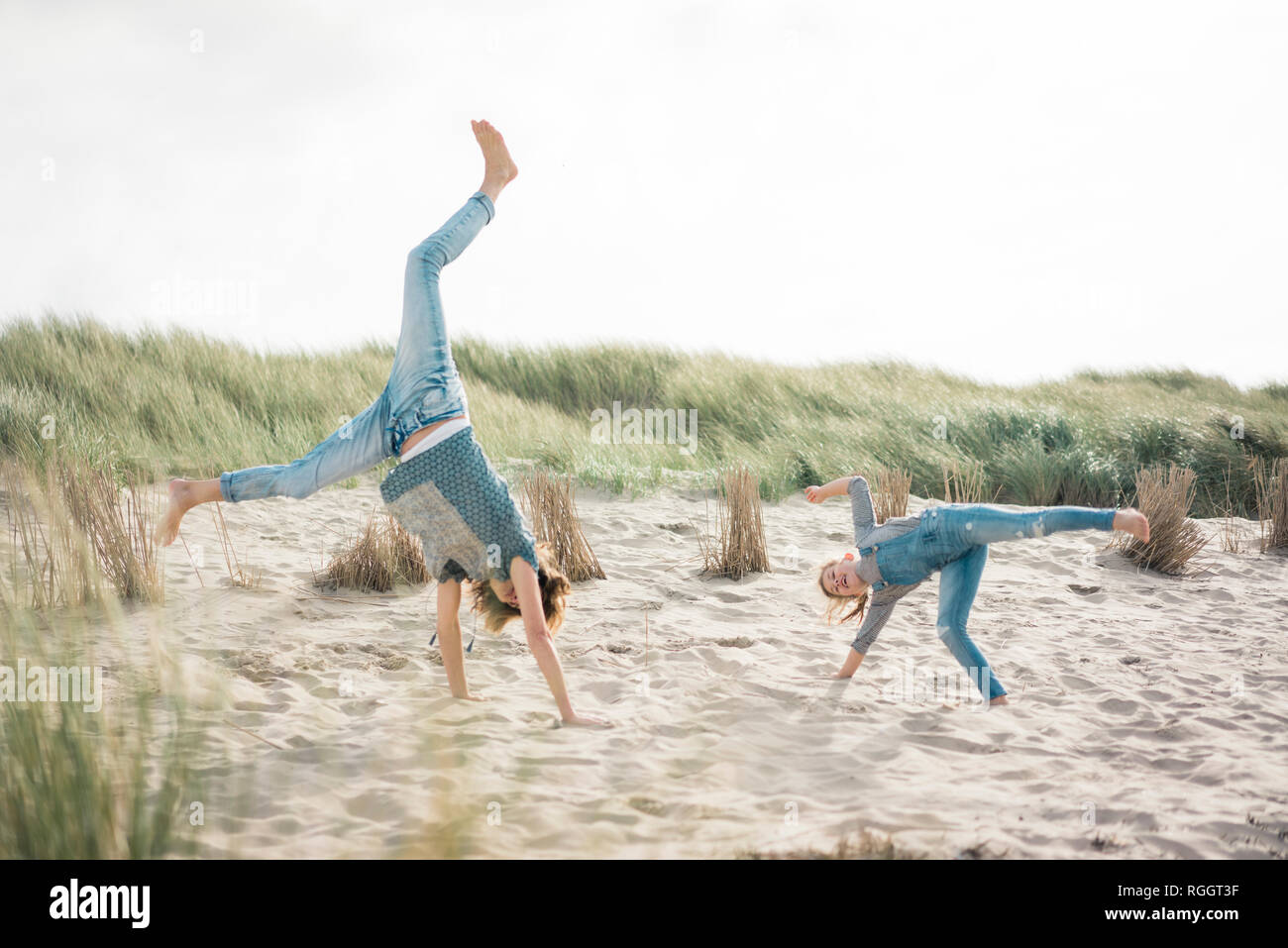 Mutter und Tochter Spaß, Cartwheeling am Strand Stockfoto