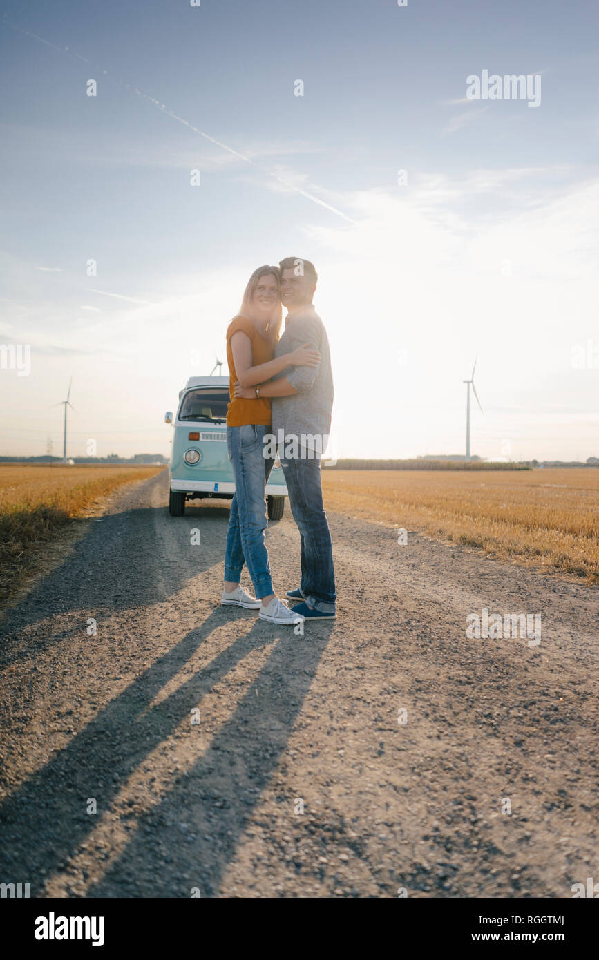 Liebevolle junge Paar stehend auf Feldweg im Wohnmobil in ländlichen Landschaft Stockfoto