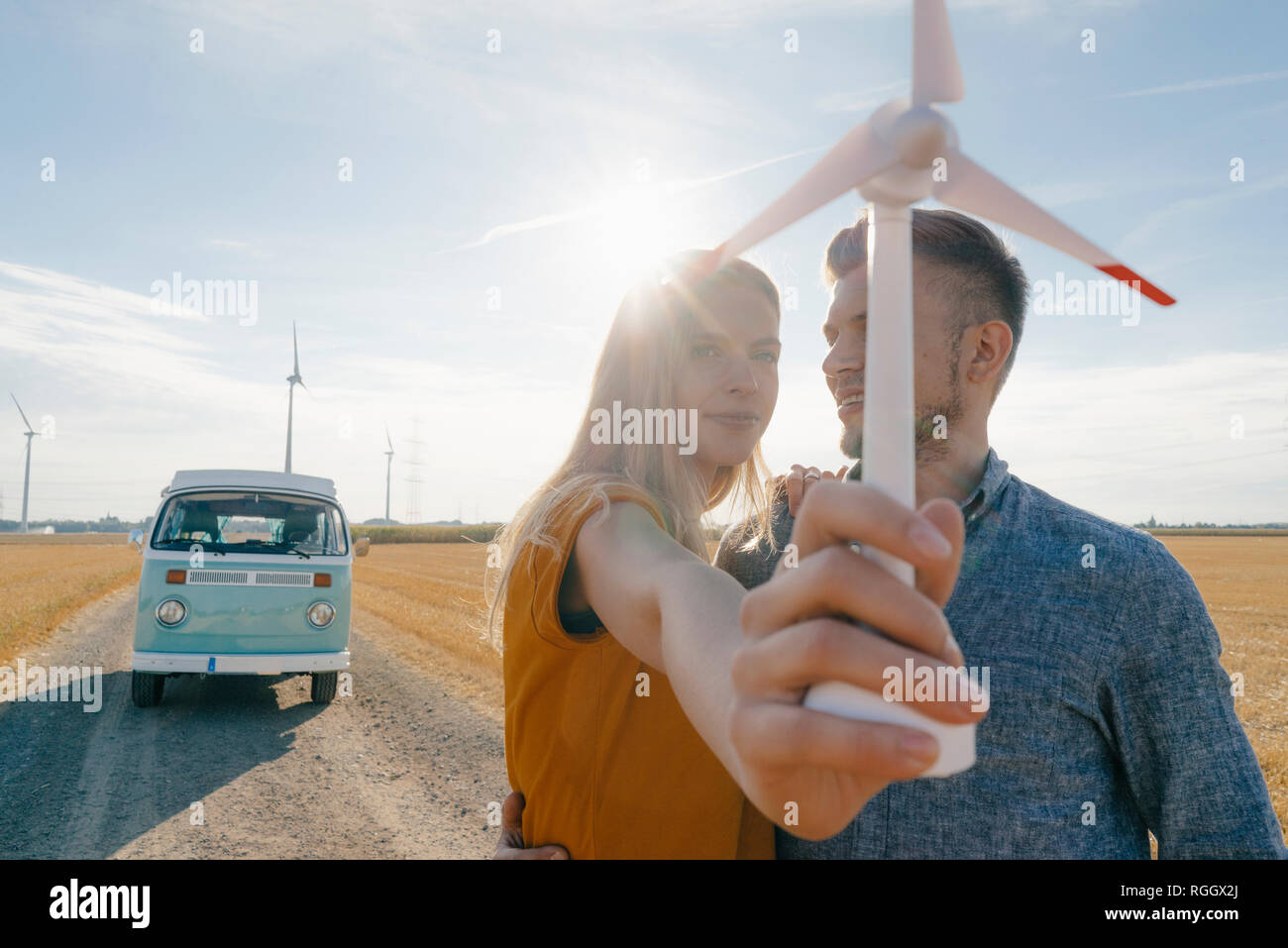 Junges Paar an Wohnmobil in ländlichen Landschaft Holding wind turbine Modell Stockfoto