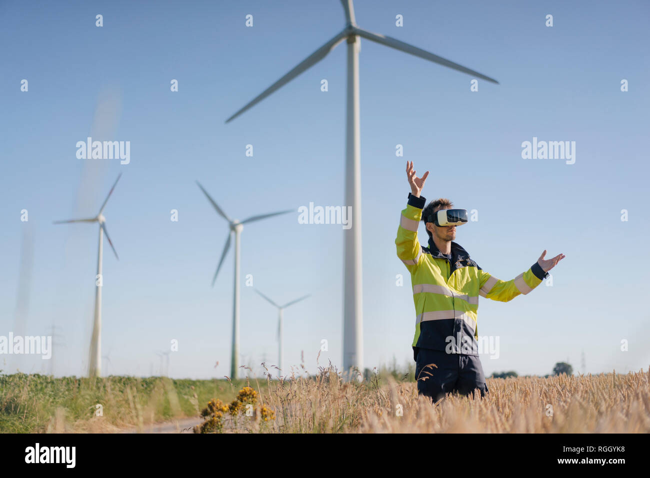 Ingenieur steht ein Feld an einem Windpark tragen VR-Brille Stockfoto