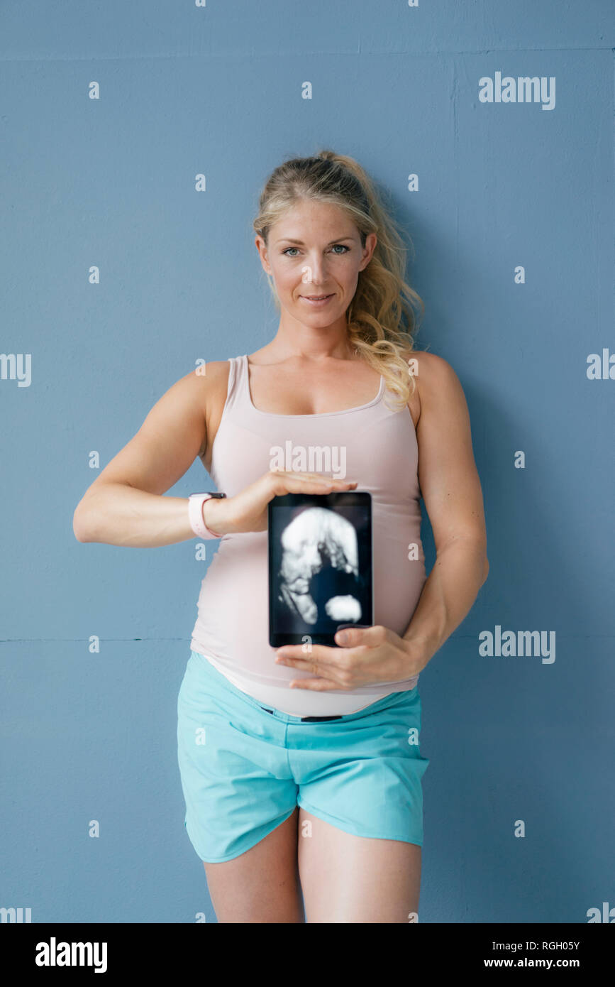 Portrait von lächelnden schwangere Frau mit Ultraschall Bild auf Tablet Stockfoto