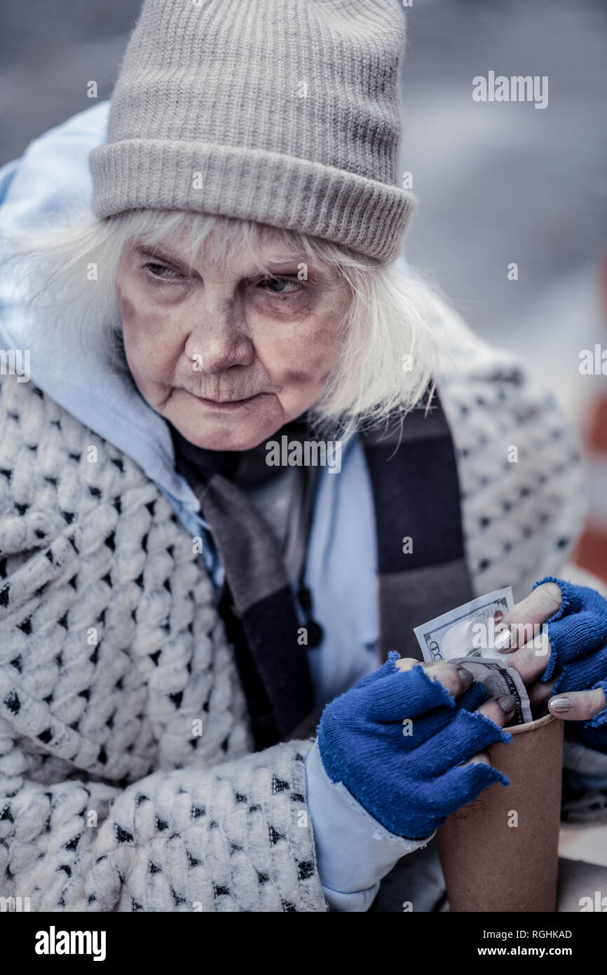 Freudlos arme Frau hundert Dollar in Stockfoto