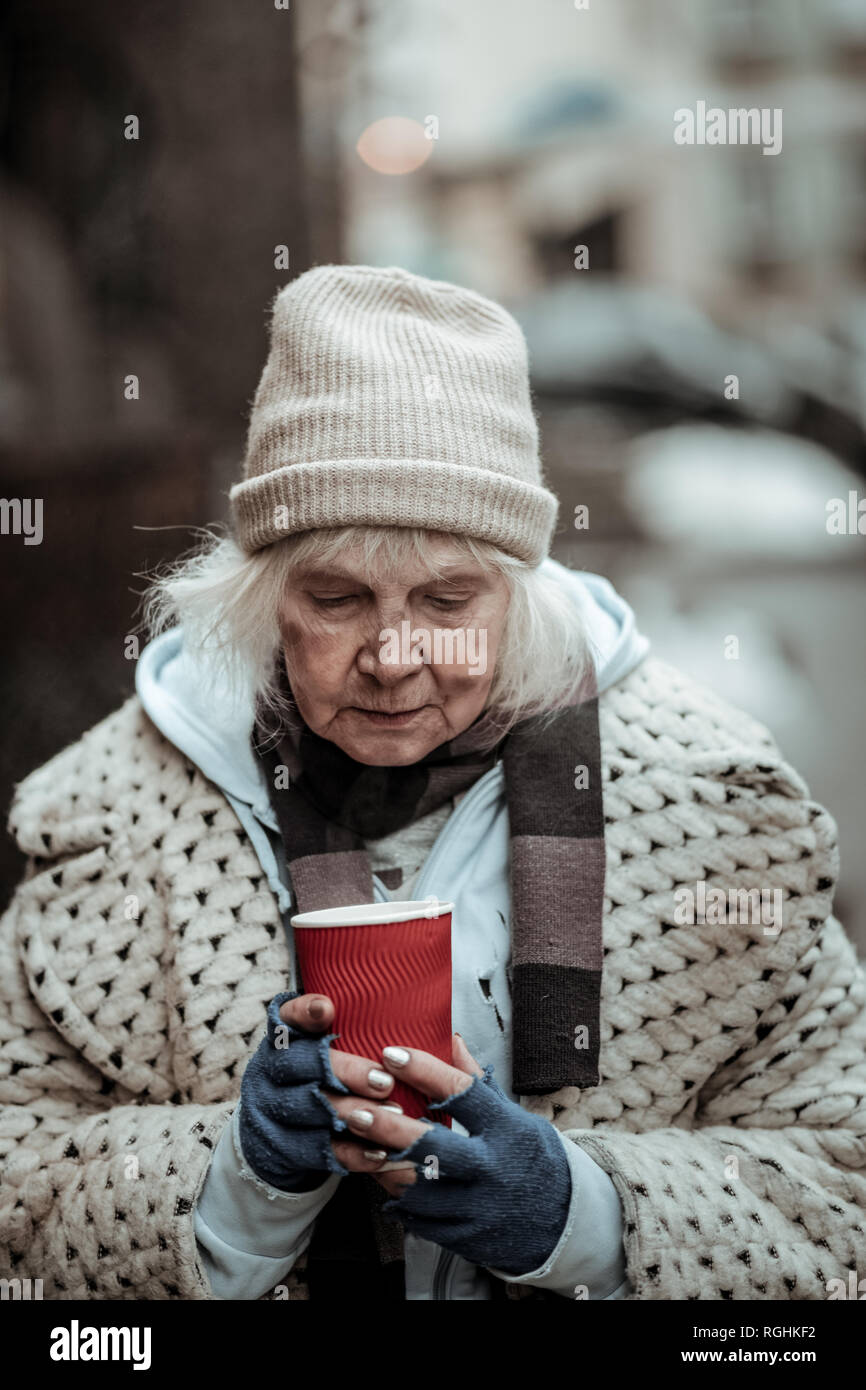 Unglücklich traurige Frau hält eine Tasse mit Kaffee Stockfoto