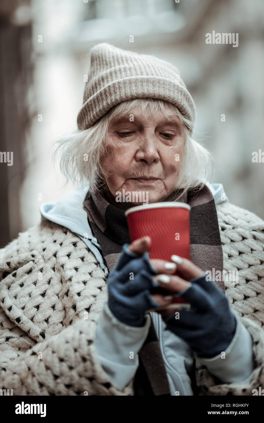 Traurig gealterte Frau in Ihre Tasse mit Kaffee Stockfoto