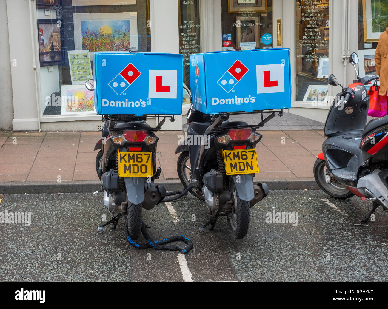 Zwei Fahrräder Domino's Pizza in Shrewsbury, Shropshire, England, UK geparkt Stockfoto