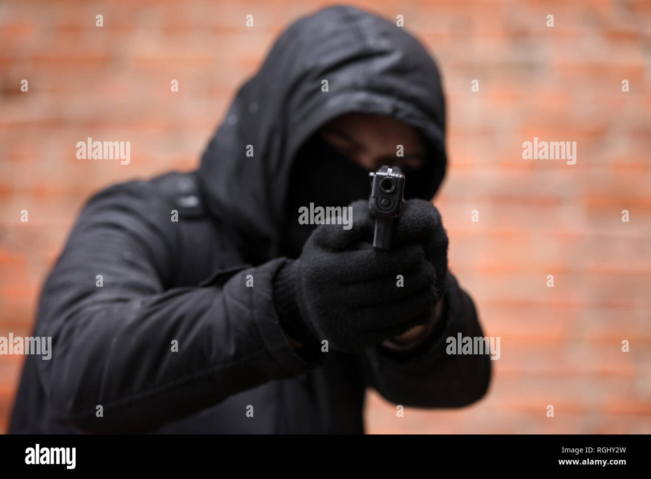 Mann im schwarzen Maske mit Pistole. Straftaten und Terrorismus Konzept Stockfoto