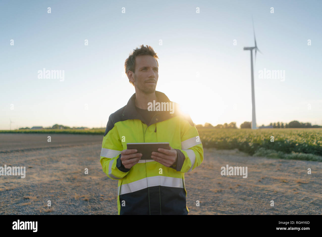 Techniker stehen in ländlichen Landschaft bei Windenergieanlagen holding Tablet Stockfoto