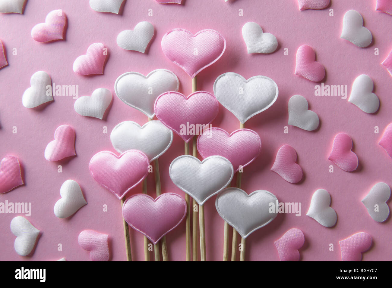 Rosa textile Herzen auf Holzstäbchen Nahaufnahme. Valentines Tag Hintergrund, kreative Textur und liebe Konzept Stockfoto
