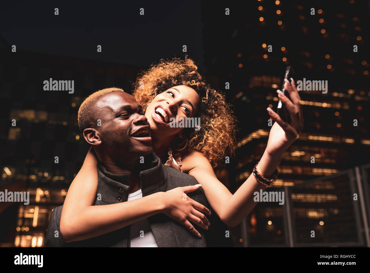 Glückliches junges Paar unter selfie in der Nacht in der Stadt Stockfoto