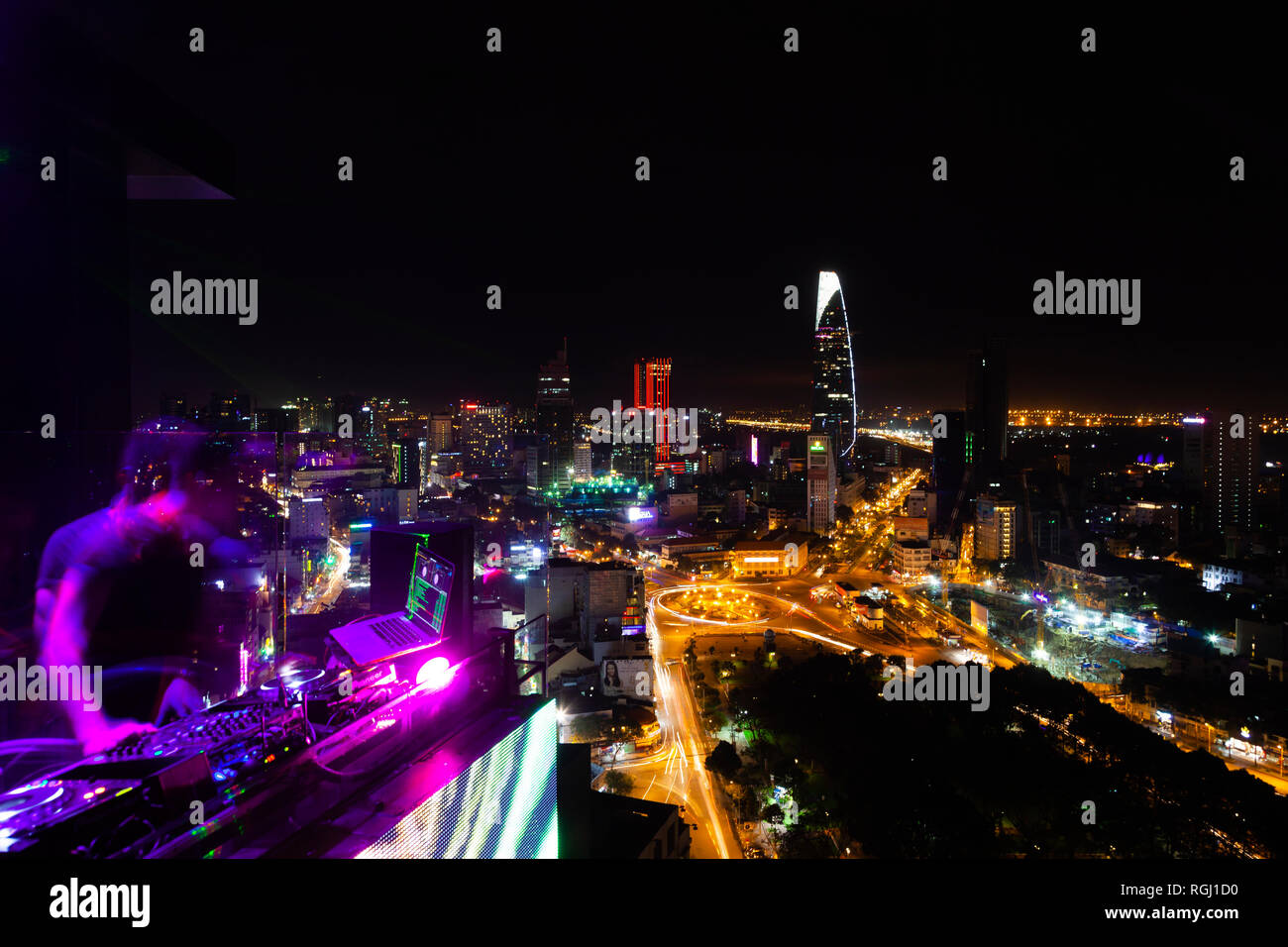Vietnam, Ho Chi Minh City bei Nacht, DJ im Vordergrund. Stockfoto