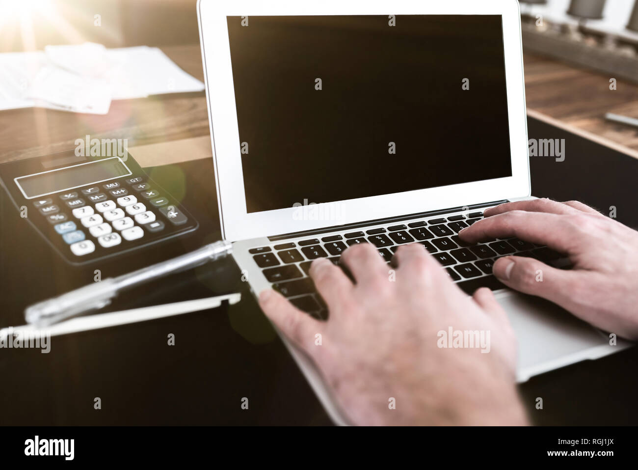 Person am Schreibtisch arbeiten an der Texteingabe auf Laptop Computer sitzen Stockfoto