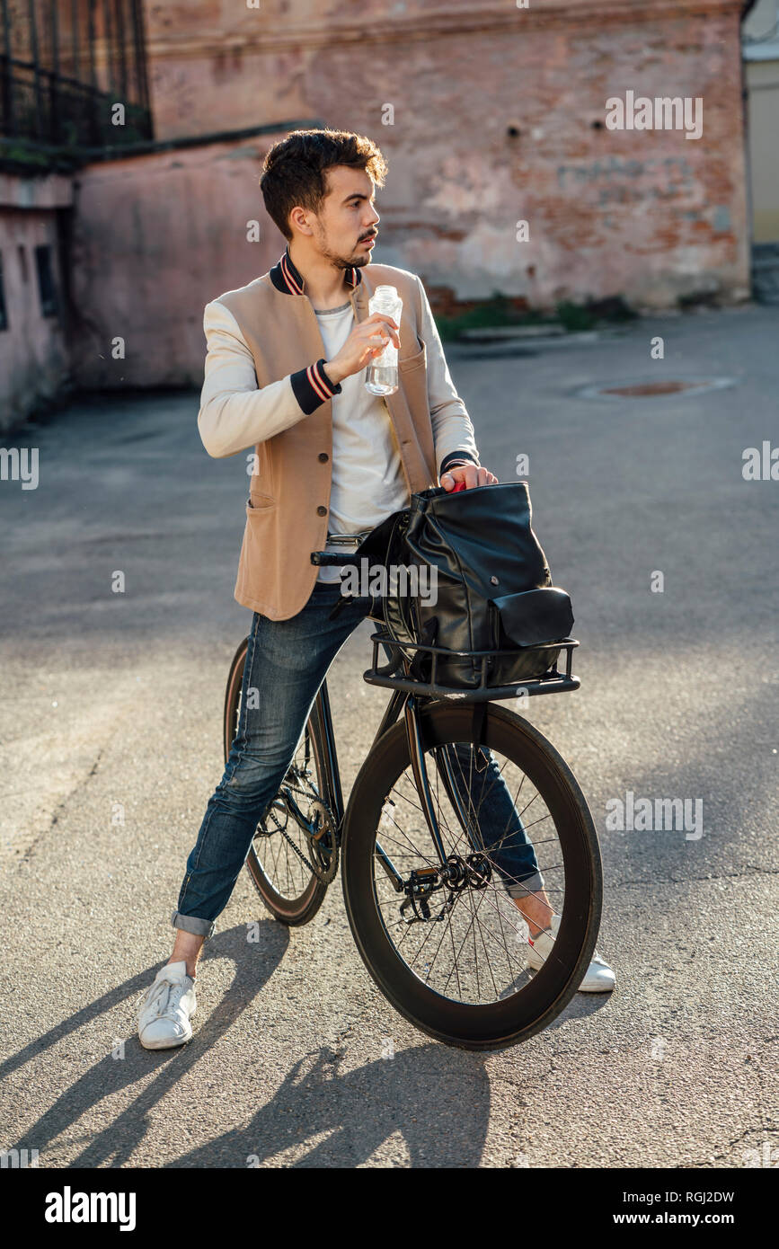 Junger Mann mit Pendler fixie Bike eine Pause auf einem Hinterhof in der Stadt Stockfoto