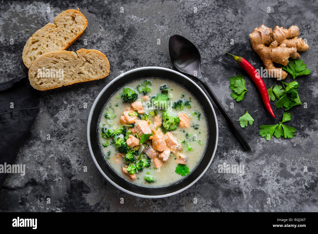 Cocos lachs Suppe, mit Brokkoli, Lauch, Kokosmilch, Petersilie, Chili, Ingwer und Baguette Stockfoto