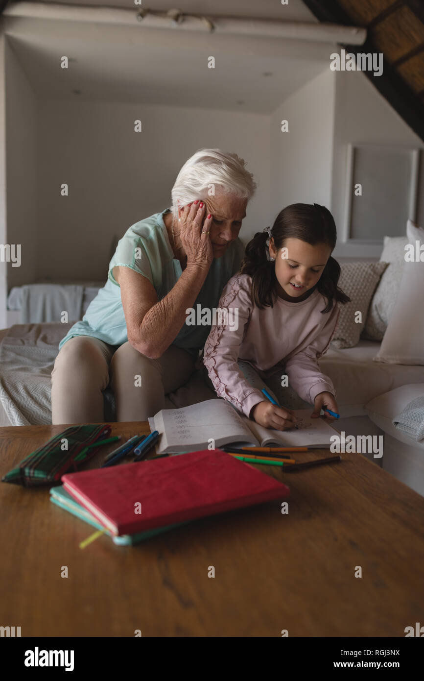 Großmutter ihrer Enkelin helfen bei Hausaufgaben Stockfoto