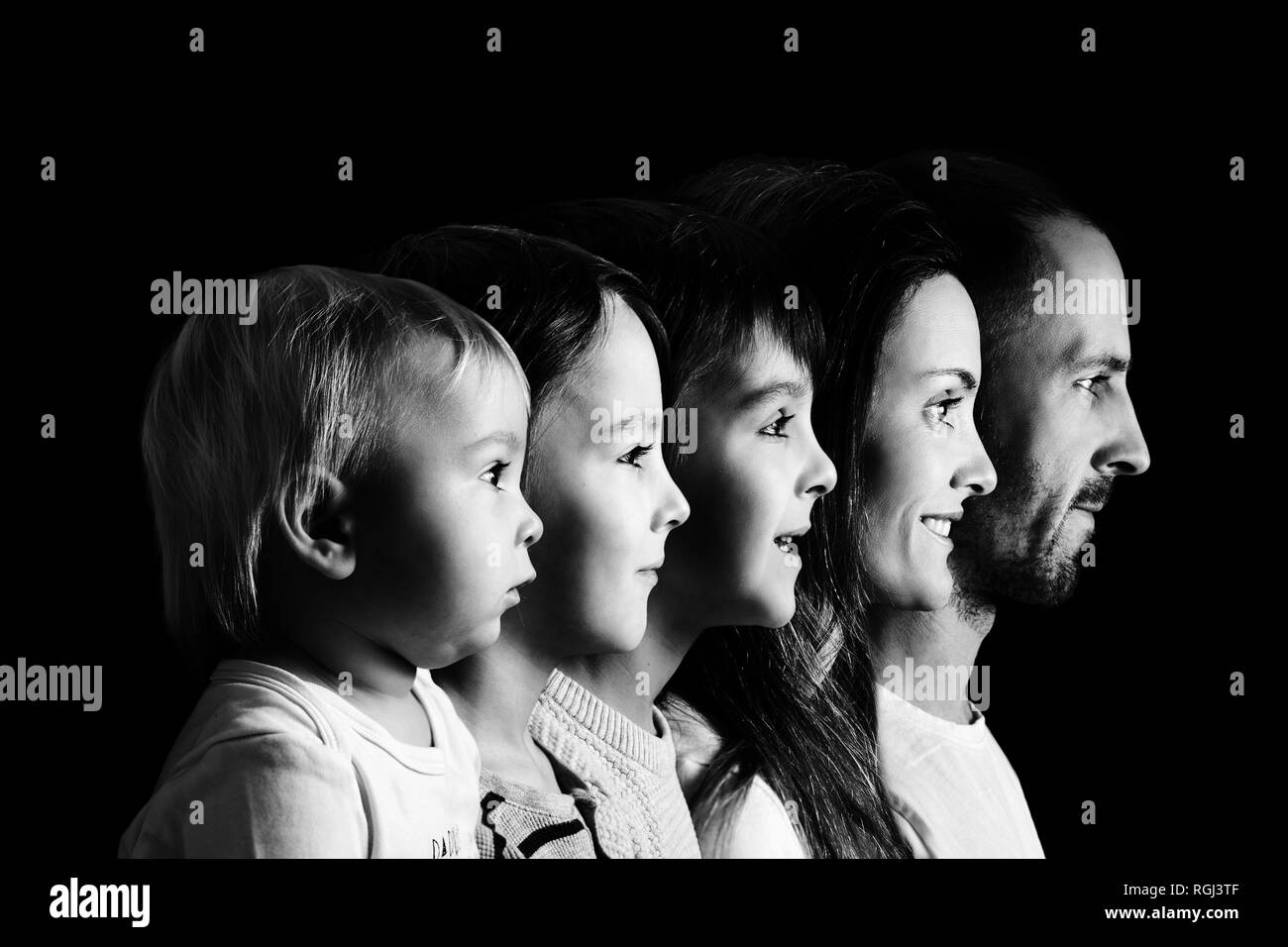 Family Portrait von Vater, Mutter und drei Jungen, Profil Bild von Ihnen alle in einer Reihe, auf schwarzem Hintergrund isoliert, Schwarzweiß-Version Stockfoto