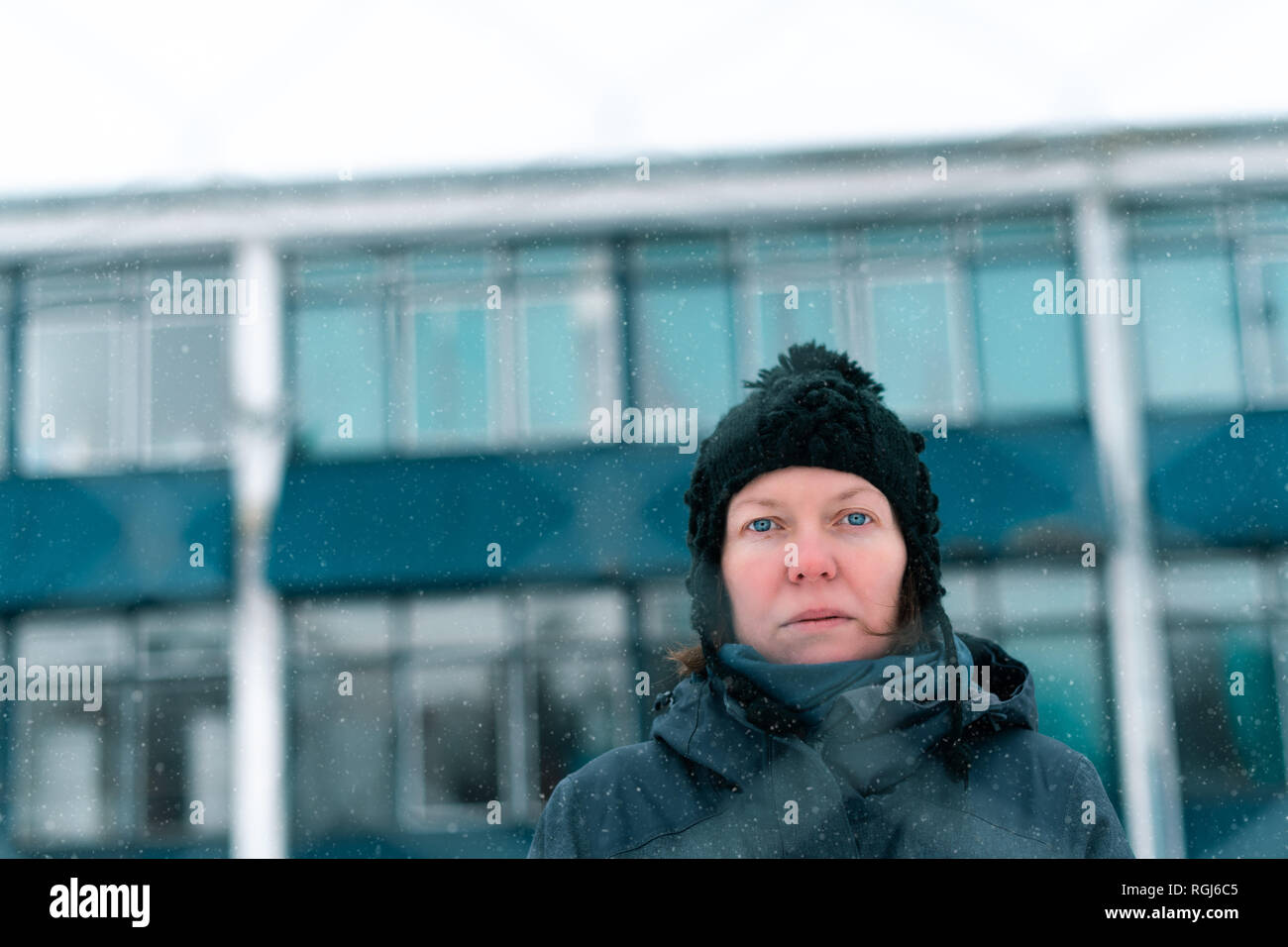Besorgt betroffenen ernsthafte Frau hinter chain-link Fence als Hindernis auf kalten Wintertag Stockfoto