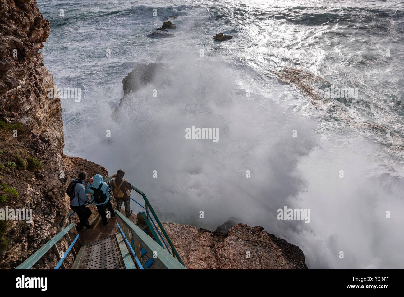 Touristische beobachten, ganz in der Nähe einer grossen Welle in Nazaré Leuchtturm Farol da Nazaré, North Beach, Praia do Norte in Nazaré, Portugal Stockfoto