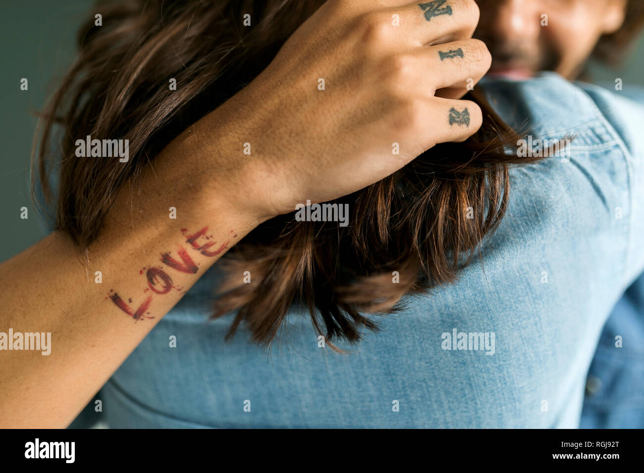 Nahaufnahme der tätowierten Mann umarmt Freundin Stockfoto