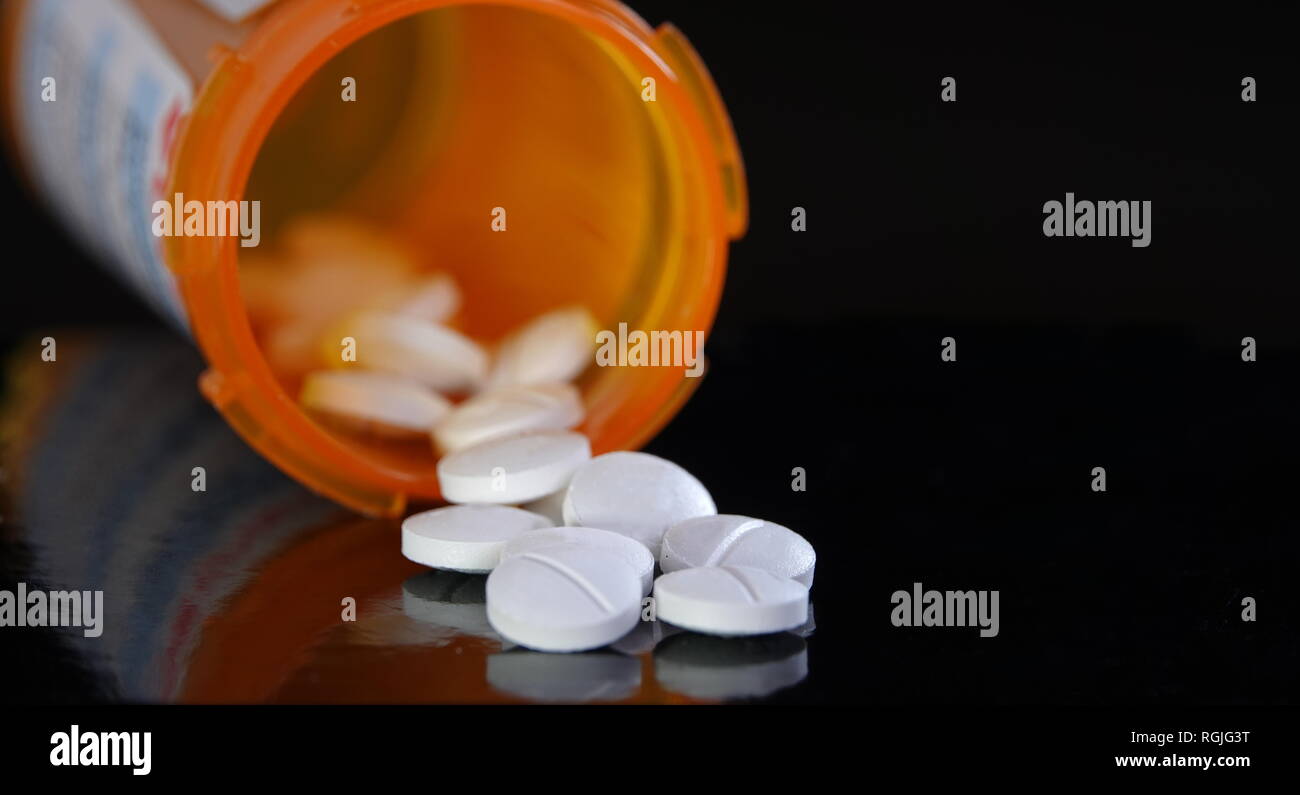 Generikum Konzept - Tabletten Verschütten von Flasche, isoliert auf Schwarz Stockfoto