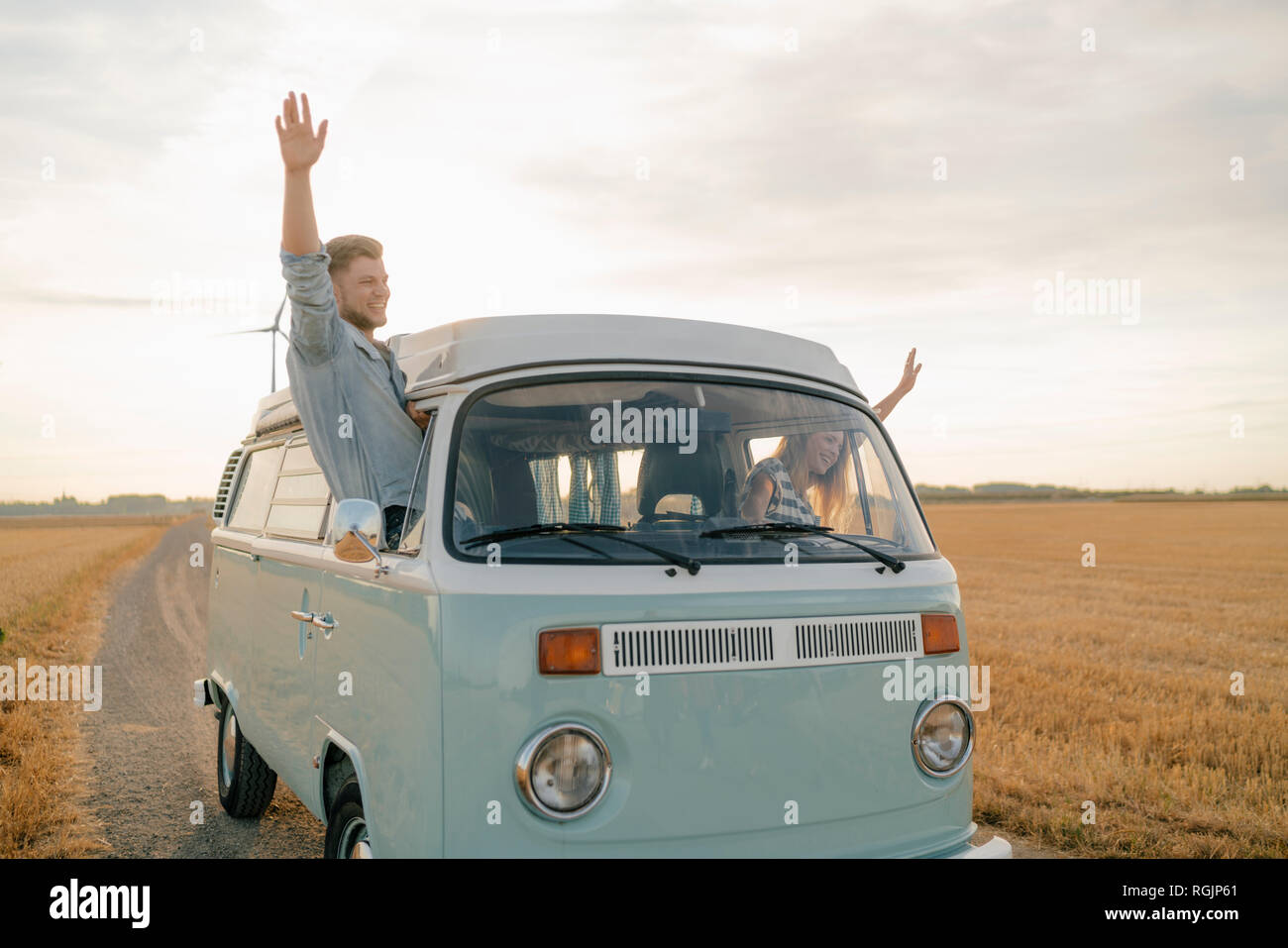 Glückliches Paar lehnte sich aus dem Fenster eines Reisemobils in ländlichen Landschaft Stockfoto