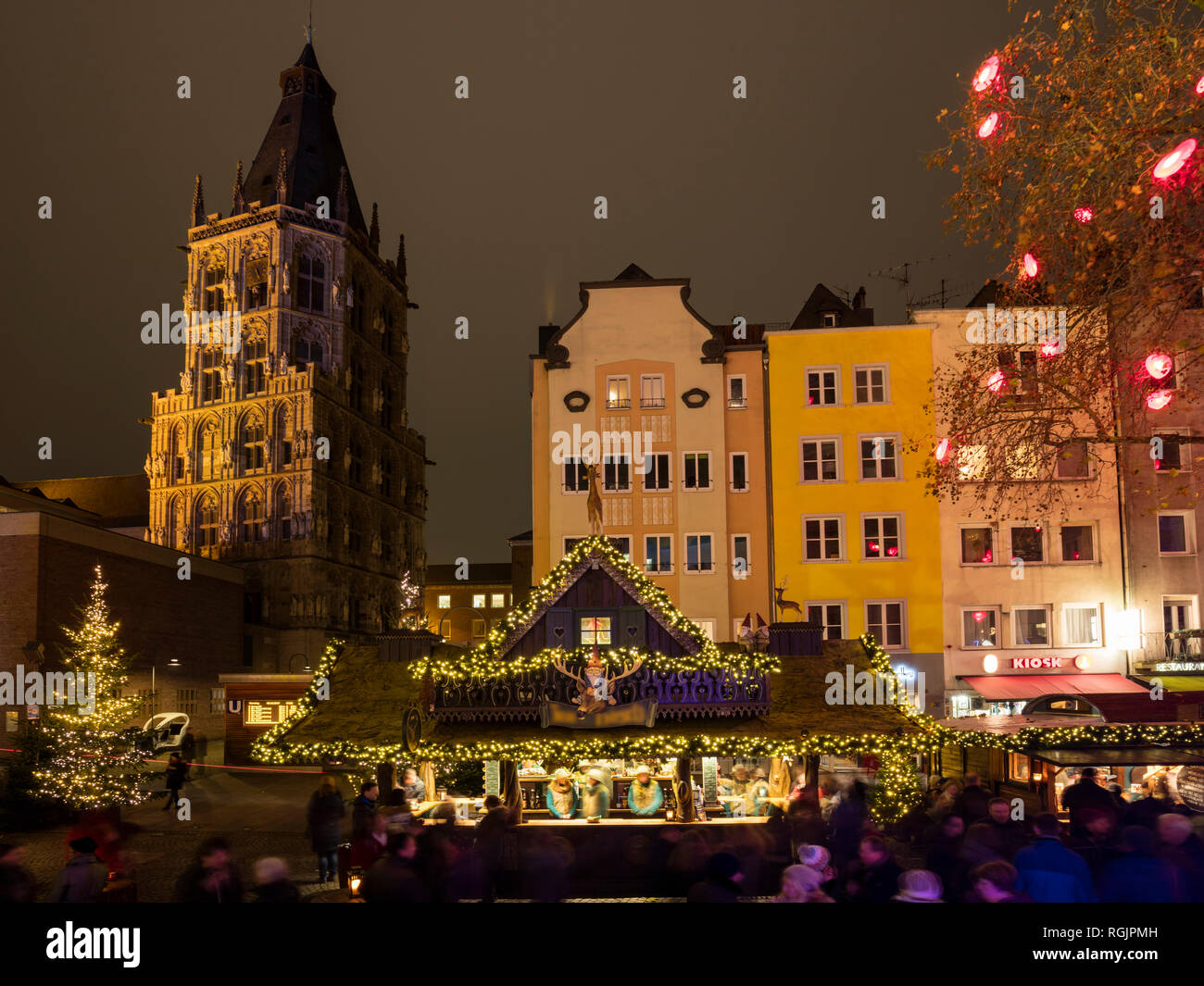 Deutschland, Köln, historisches Rathaus und Reihe von Häusern mit Weihnachtsmarkt im Vordergrund. Stockfoto