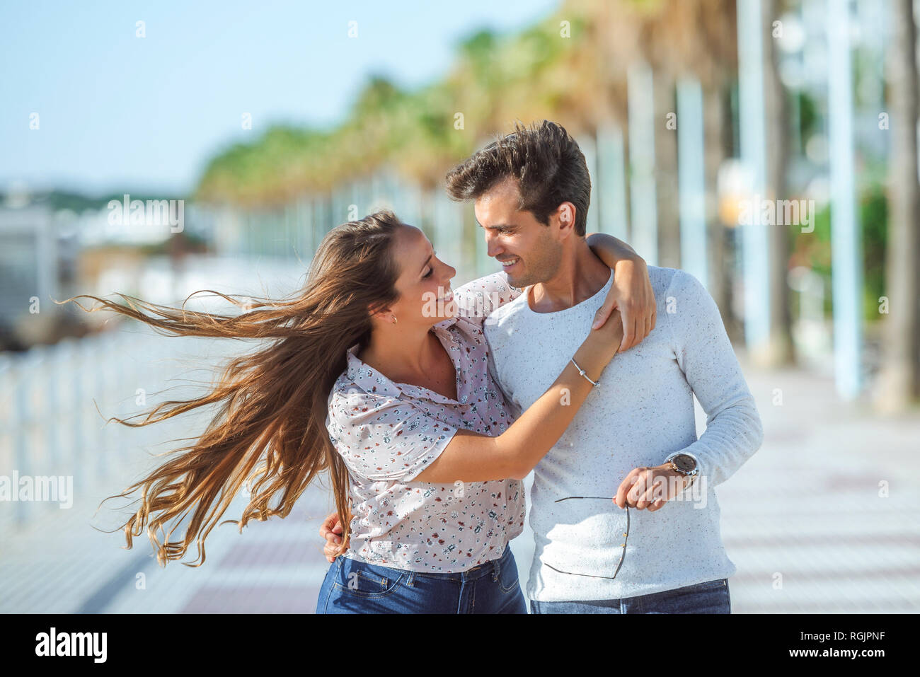 Glückliches junges Paar umarmen an der Promenade Stockfoto