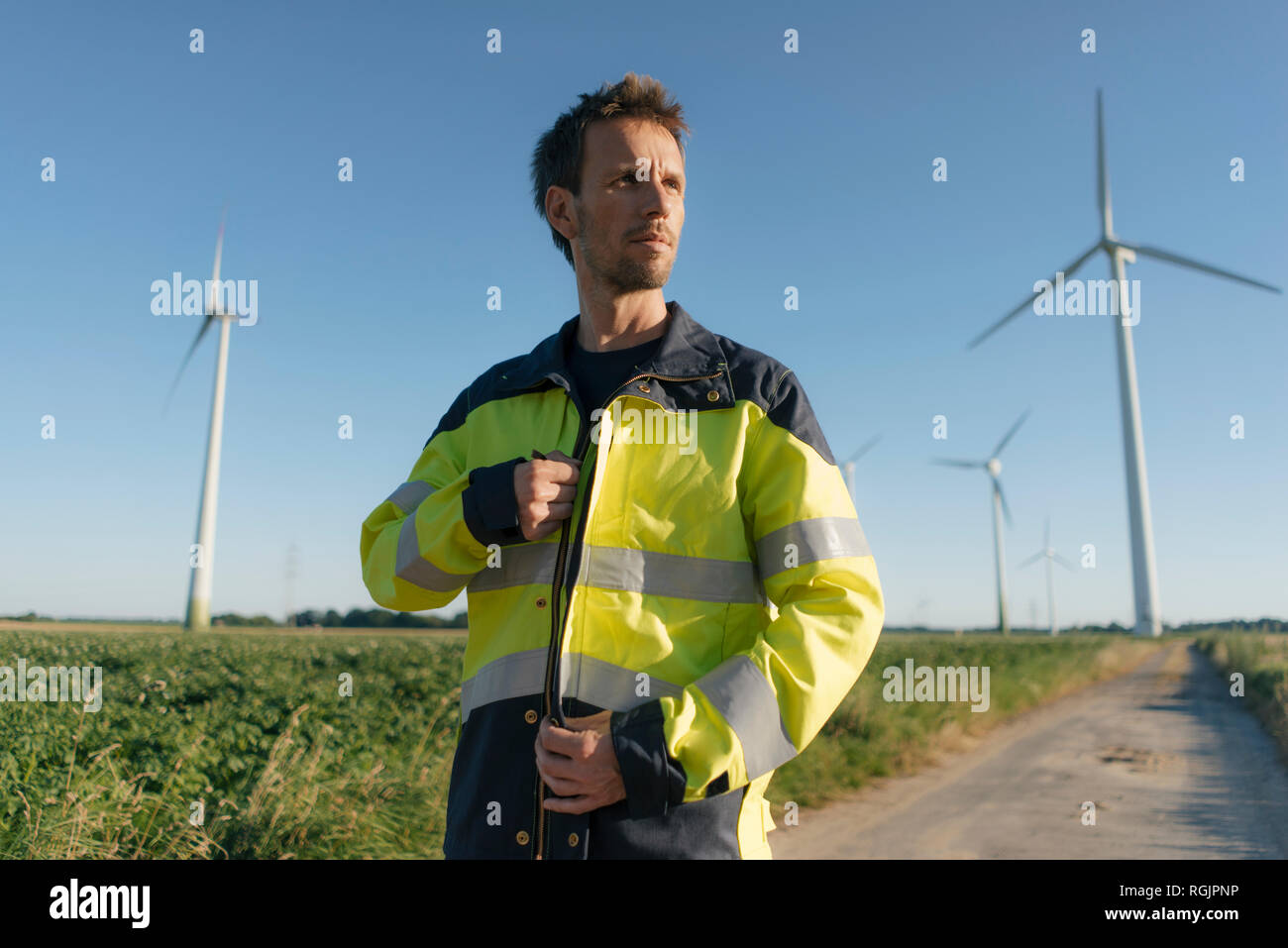 Porträt eines Ingenieurs im Feld Pfad zu einem Windpark Stockfoto