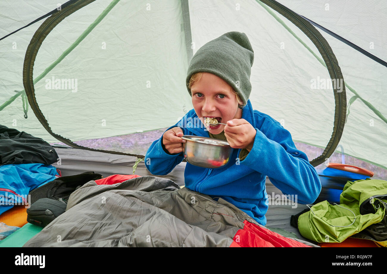 Bolivien, La Paz, Junge, Essen aus der Schüssel im Zelt Stockfoto