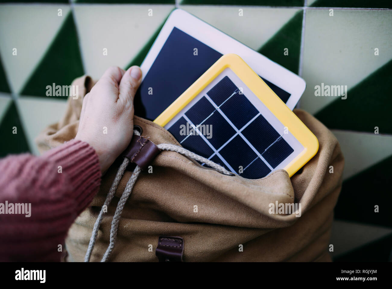 Frau, eine Tablette in einen Rucksack mit einem Solarpanel Ladegerät Stockfoto