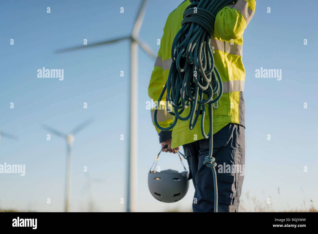 Nahaufnahme des Technikers an einen Windpark mit Kletterausrüstung Stockfoto