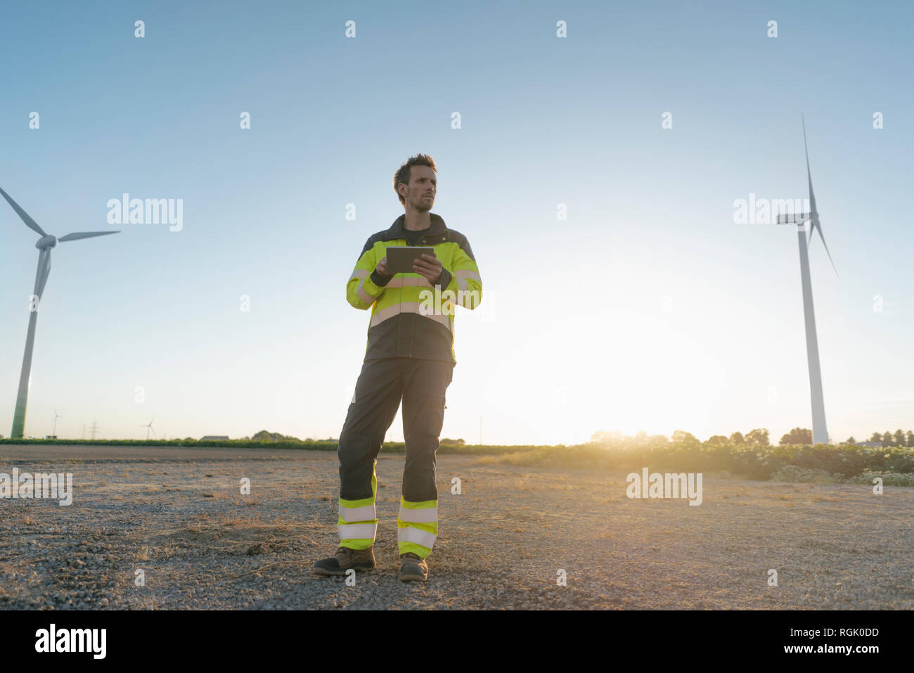 Techniker stehen in ländlichen Landschaft an einem Windpark Holding tablet Stockfoto